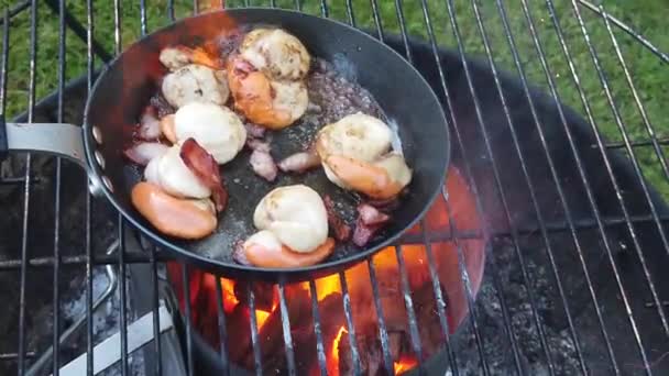 Verse Sint-jakobsschelpen worden geflambeerd met boter en spek op een barbecue. Slow Motion — Stockvideo