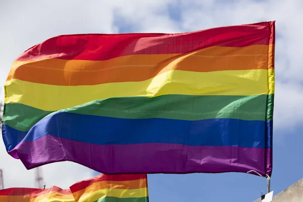 Um LGBT gay orgulho arco-íris bandeira sendo ondulado no um orgulho comunidade celebração evento — Fotografia de Stock