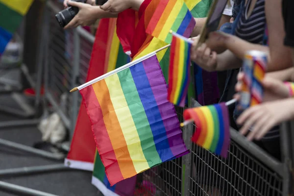 Zuschauer schwenken eine schwule Regenbogenfahne bei einem LGBT Gay Pride Community Event — Stockfoto