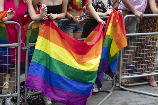 Los espectadores ondean una bandera arco iris gay en un evento de la comunidad LGBT orgullo gay —  Fotos de Stock