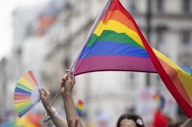 Bir Lgbtq gökkuşağı bayrağı bir gay gurur yürüyüşünde havada yüksek salladı ediliyor