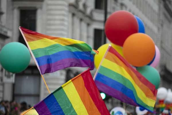 Pessoas onda LGBTQ gay orgulho arco-íris bandeiras no um orgulho evento — Fotografia de Stock