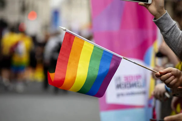 Gli spettatori sventolano una bandiera dell'arcobaleno gay a un evento della comunità gay pride LGBT — Foto Stock