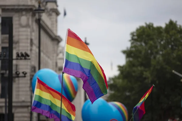 Gay orgulho arco-íris bandeiras sendo ondulado no o ar no um orgulho evento — Fotografia de Stock