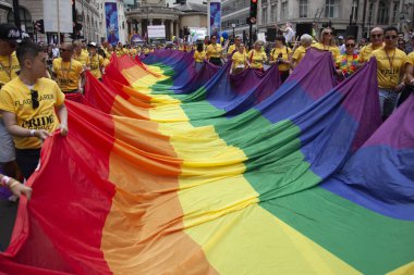 Londra, Ingiltere-6 Temmuz 2019: Insanlar Londra gurur olayın başlangıcında büyük bir LGBTQ gay gurur gökkuşağı bayrağı tutun