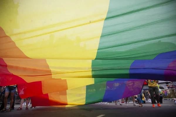 LONDRES, Reino Unido - 6 de julio de 2019: La gente sostiene una enorme bandera del arco iris del orgullo gay LGBTQ al comienzo del evento del orgullo de Londres — Foto de Stock