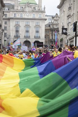 Londra, Ingiltere-6 Temmuz 2019: Insanlar Londra gurur olayın başlangıcında büyük bir LGBTQ gay gurur gökkuşağı bayrağı tutun