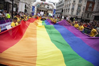 Londra, Ingiltere-6 Temmuz 2019: Insanlar Londra gurur olayın başlangıcında büyük bir LGBTQ gay gurur gökkuşağı bayrağı tutun