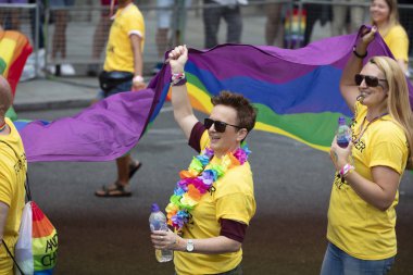 Londra, Ingiltere-6 Temmuz 2019: Insanlar Londra gurur olayın başlangıcında büyük bir LGBTQ gay gurur gökkuşağı bayrağı tutun