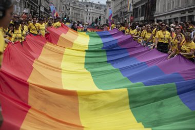 Londra, Ingiltere-6 Temmuz 2019: Insanlar Londra gurur olayın başlangıcında büyük bir LGBTQ gay gurur gökkuşağı bayrağı tutun