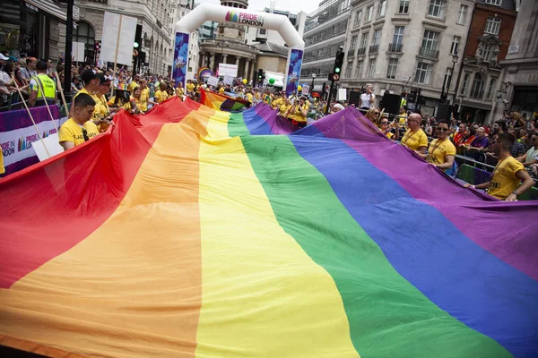 Londyn, Wielka Brytania-6 lipca 2019: ludzie posiadają ogromną flagę LGBTQ Gay dumy tęczy na początku imprezy dumy londyńskiej — Zdjęcie stockowe