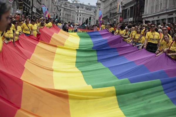 LONDRES, Reino Unido - 6 de julio de 2019: La gente sostiene una enorme bandera del arco iris del orgullo gay LGBTQ al comienzo del evento del orgullo de Londres —  Fotos de Stock