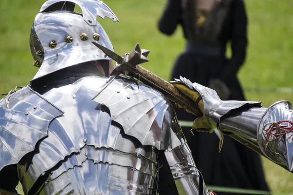 Two medieval knights in armour battle with weapons Stock Image