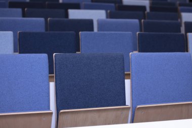 Bir konferans odasında boş mavi sandalye satır