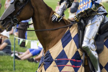 Parlak zırh giyen bir atın üzerinde oturan bir ortaçağ şövalyesi