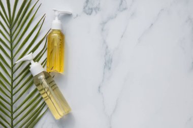 Tropikal palmiye yaprağı ile mermer arka plan üzerinde cilt bakımı ve kozmetik ürünleri