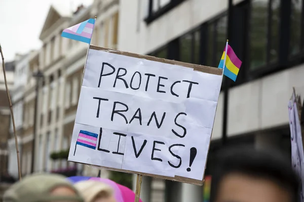 Een persoon die houder is van een teken lezen Bescherm trans Lives banner — Stockfoto