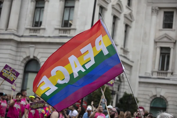 LONDRES, Reino Unido - 6 de julho de 2019: pessoas acenam com bandeiras de orgulho gay LGBTQ em uma marcha de solidariedade — Fotografia de Stock