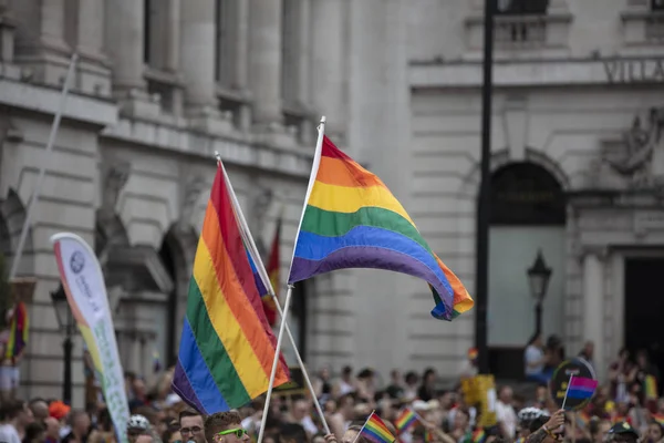 LONDRES, Reino Unido - 6 de julho de 2019: pessoas acenam com bandeiras de orgulho gay LGBTQ em uma marcha de solidariedade — Fotografia de Stock