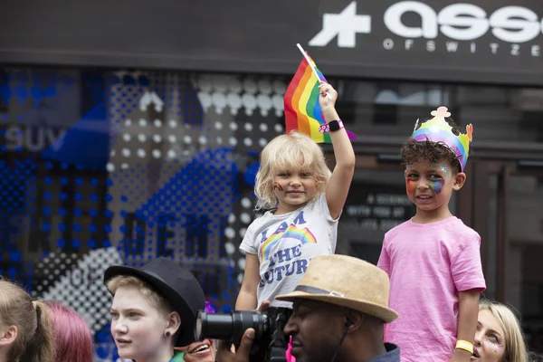 London, Großbritannien - 6. Juli 2019: Zuschauer mit Regenbogenfahnen verfolgen die jährliche Pride Parade — Stockfoto