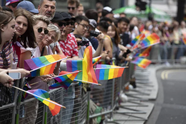 London, Großbritannien - 6. Juli 2019: Zuschauer, die die jährliche Pride Parade beobachten, bei der die Flaggen der Gay Pride geschwenkt werden — Stockfoto