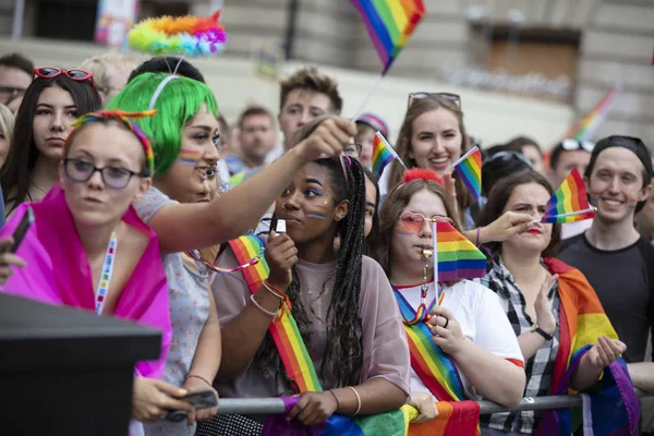 LONDON, Reino Unido - 6 de julho de 2019: Espectadores com bandeiras de arco-íris assistindo ao desfile anual de orgulho — Fotografia de Stock