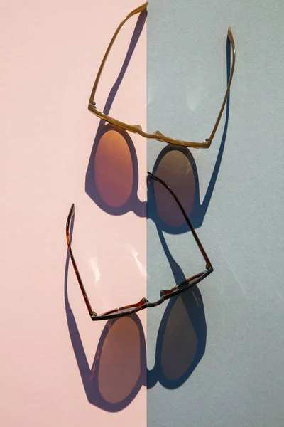 Όμορφα καλοκαιρινά γυαλιά ηλίου με μακρά σκιά σε ροζ και μπλε φόντο — Φωτογραφία Αρχείου