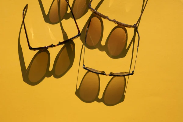 Γυαλιά ηλίου με μακρά σκιά σε ένα brignt καλοκαιρινό κίτρινο φόντο — Φωτογραφία Αρχείου