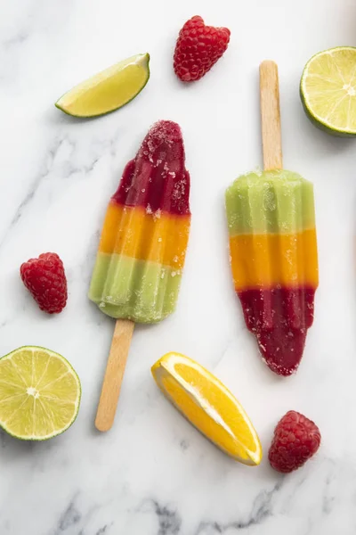 Summer fruit ice lollies made with orange lime and raspberries