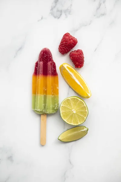 Summer fruit ice lollies made with orange lime and raspberries