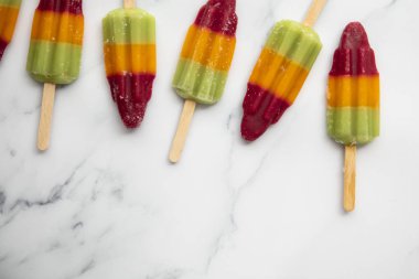 Mermer bir arka plan üzerinde yaz meyve buz lolly popcicle