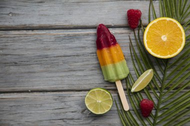 Meyve ve ahşap bir arka plan üzerinde tropikal palmiye yaprağı ile Yaz buz lollies