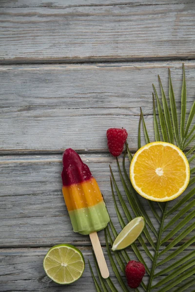 Meyve ve ahşap bir arka plan üzerinde tropikal palmiye yaprağı ile Yaz buz lollies