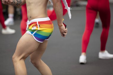 Bir gurur etkinliğinde sokakta dans eşcinsel gurur bayrağı şort giyen bir adam