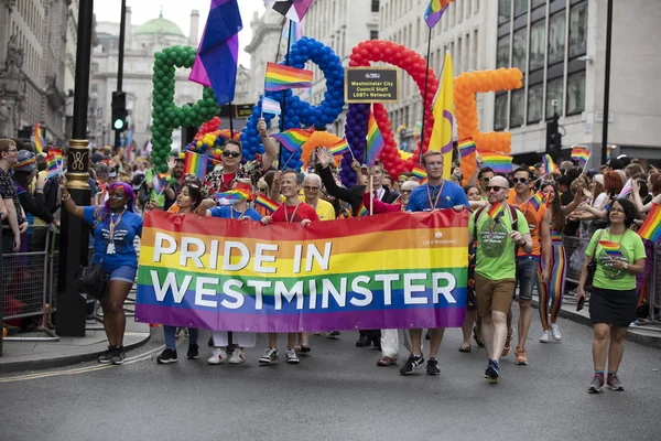 ロンドン、英国 - 2019年7月6日:ロンドン中心部で毎年行われるゲイプライド行進でウェストミンスターの旗を掲げる人々 — ストック写真