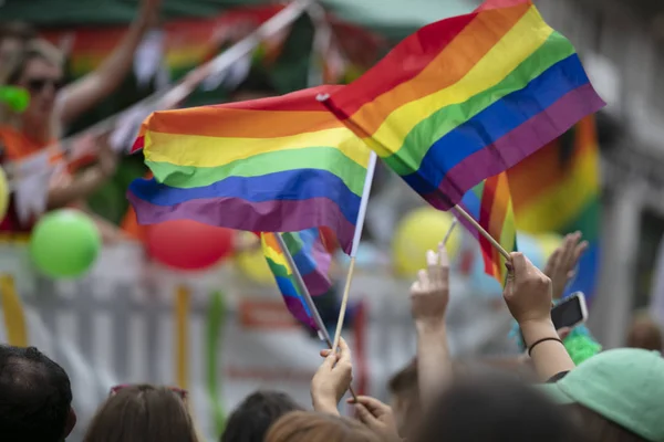 La gente agita banderas de orgullo gay LGBTQ en una marcha solidaria — Foto de Stock