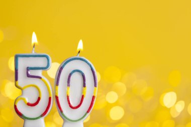 Number 50 birthday celebration candle against a bright lights an clipart