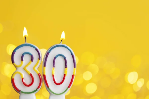 Numéro 30 bougie de célébration d'anniversaire contre une lumière vive et — Photo