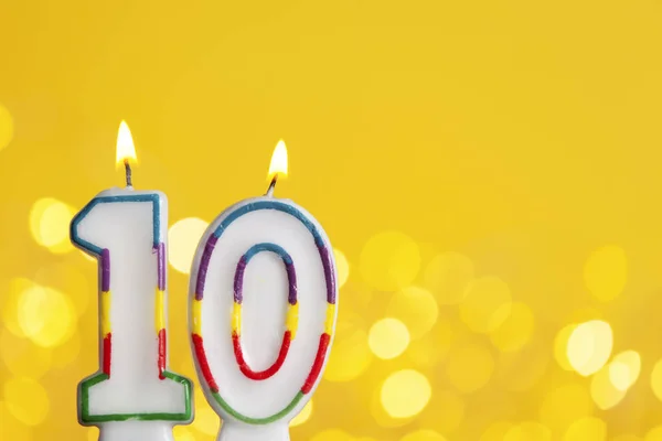Número 10 vela de celebración de cumpleaños contra una luz brillante un — Foto de Stock
