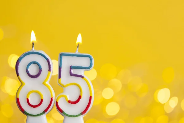 Číslo 85 narozeninová svíčka proti jasném osvětlení a — Stock fotografie