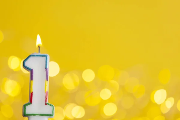 Святкування першого дня народження свічка проти яскравих вогнів і — стокове фото