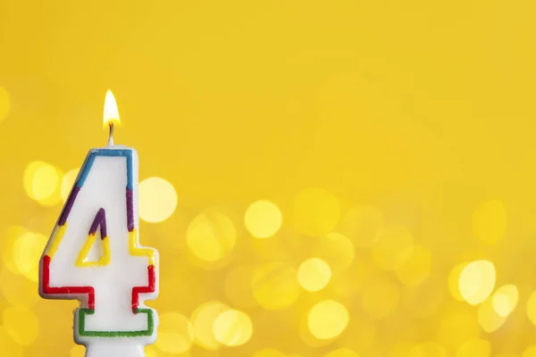 Number 4 birthday celebration candle against a bright lights and — Stock Photo, Image