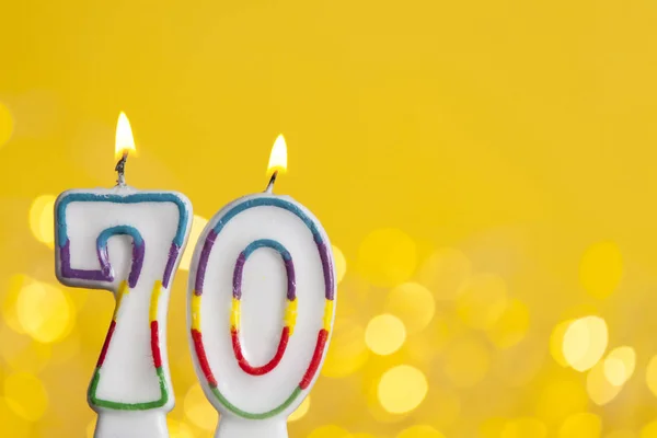 Número 70 vela de celebración de cumpleaños contra una luz brillante un — Foto de Stock