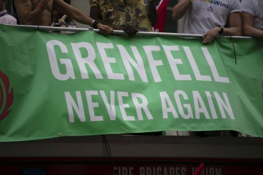 LONDON, UK - July 6th 2019: People hold a Grenfell never again sign in memory of the genfell tower disaster clipart