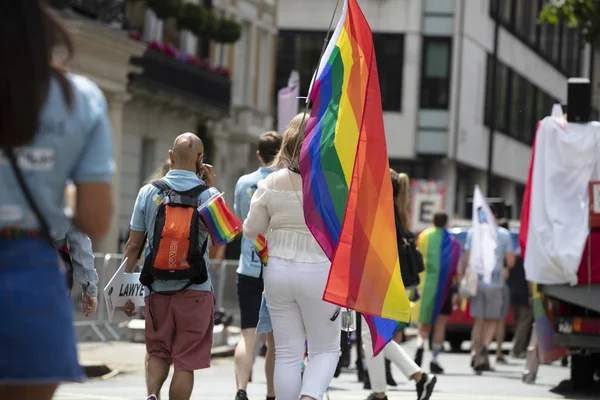 Londyn, Wielka Brytania-6 lipca 2019: osoba carrys dużą flagę gej dumy Dring rocznego marszu dumy w Londynie — Zdjęcie stockowe