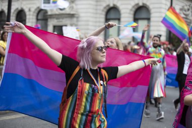 Londra, İngiltere - 6 Temmuz 2019: Londra'da eşcinsel gurur yürüyüşünde bir kişi biseksüel gurur bayrağı nı diker