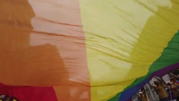 London, Storbritannien-6 juli 2019: människor innehar en enorm HBTQ Gay Pride Rainbow Flag i början av London Pride-evenemanget — Stockvideo