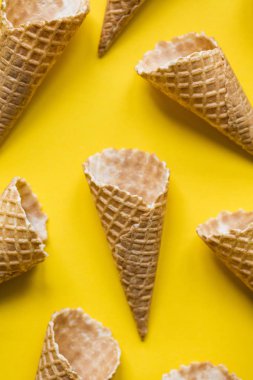 Parlak sarı arka planda boş waffle gofret dondurma koni