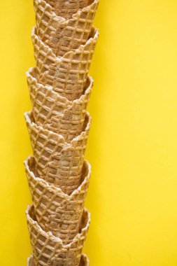 Parlak sarı arka planda boş waffle gofret dondurma koni