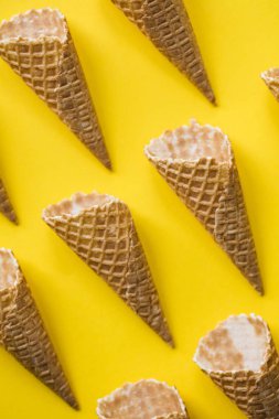 Parlak sarı arka planda boş waffle gofret dondurma koni